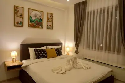a bedroom with a bed with a towel animal on it at Nlux 30 MamaBaba Resort&Spa in Kopaonik