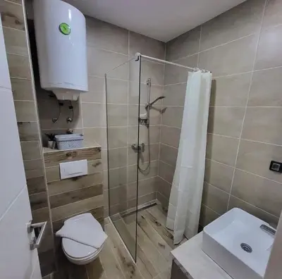 a bathroom with a shower and a toilet and a sink at Nlux 30 MamaBaba Resort&Spa in Kopaonik