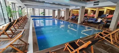 a large swimming pool with chairs in a hotel at Nlux 30 MamaBaba Resort&Spa in Kopaonik