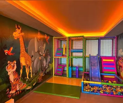 a play room with a mural of animals on the wall at Nlux 30 MamaBaba Resort&Spa in Kopaonik