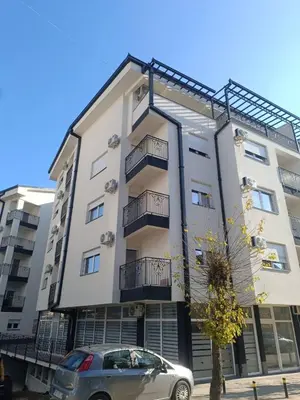 a building with a car parked in front of it at Apartman Petar i Dunja in Vranje
