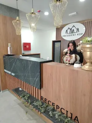 a woman sitting at a reception desk in a store at Apartman Alastra AP 02 President Kop in Kopaonik