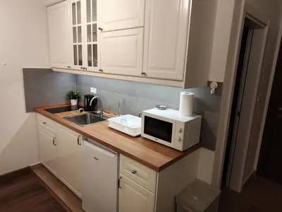 a kitchen with white cabinets and a sink and a microwave at Apartman Alastra AP 02 President Kop in Kopaonik
