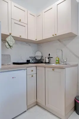 a white kitchen with white cabinets and a sink at Apartman Svitanje Vrnjacka banja in Vrnjačka Banja