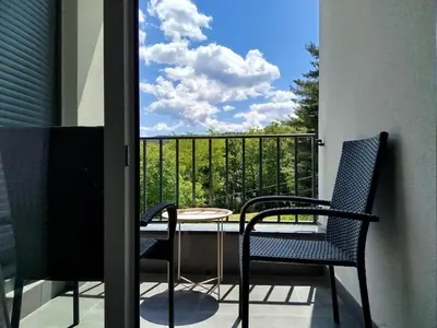 a balcony with a table and two chairs and a window at Apartman Svitanje Vrnjacka banja in Vrnjačka Banja