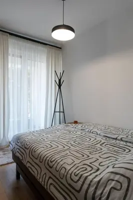 a bedroom with a large bed with a large window at Apartman Svitanje Vrnjacka banja in Vrnjačka Banja