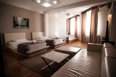 a living room with two beds and a couch at Garni Uni Elita Lux Hotel in Niš