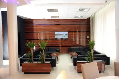 a waiting room with couches and plants at Garni Uni Elita Lux Hotel in Niš