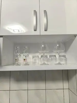 a row of wine glasses sitting on a shelf at Apartman Plava nota in Vrnjačka Banja