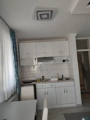 a small kitchen with white cabinets and a sink at Apartman Plava nota in Vrnjačka Banja