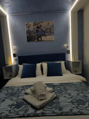 a bedroom with a large bed with blue walls at Apartman Plava nota in Vrnjačka Banja