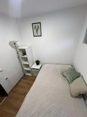a small bedroom with a bed and a lamp at Mountain Nook in Kopaonik