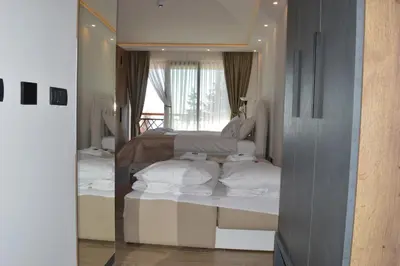 a reflection of a bedroom with a bed in a mirror at Deluxe Mountain View Studio ViS in Residence Hill Hotel Kopaonik in Kopaonik