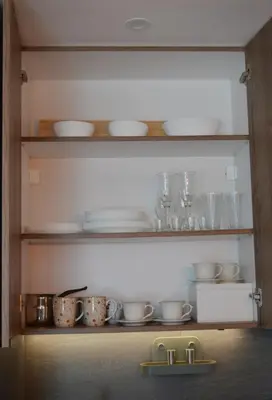 a kitchen with plates and dishes on shelves at Deluxe Mountain View Studio ViS in Residence Hill Hotel Kopaonik in Kopaonik