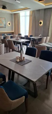 a dining room with tables and chairs and a table and chairs at Deluxe Mountain View Studio ViS in Residence Hill Hotel Kopaonik in Kopaonik