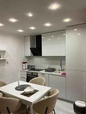 a kitchen with a white table and chairs at Aurora Nis in Niš