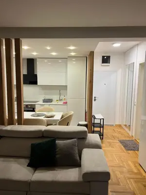 a living room with a couch and a kitchen at Aurora Nis in Niš