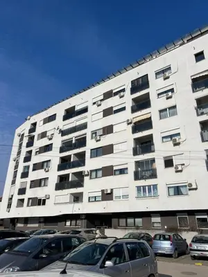 a large white building with cars parked in front of it at Aurora Nis in Niš