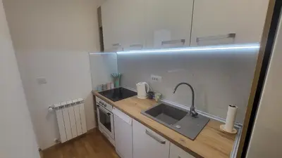 a small kitchen with a sink and a counter at Konatar Apartmants in Kruševac