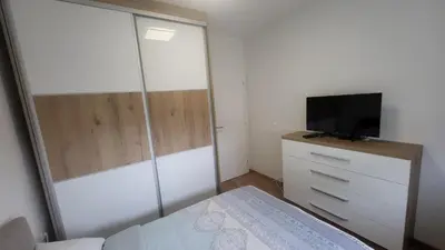 a bedroom with a bed and a tv on a dresser at Konatar Apartmants in Kruševac