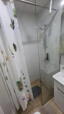 a bathroom with a shower curtain with flowers on it at Konatar Apartmants in Kruševac