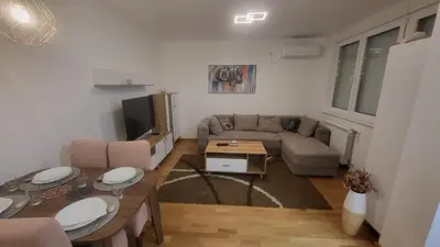 a living room with a couch and a table at Konatar Apartmants in Kruševac