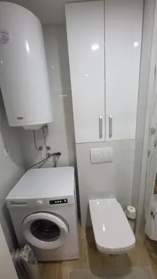 a small bathroom with a washing machine and a toilet at Konatar Apartmants in Kruševac