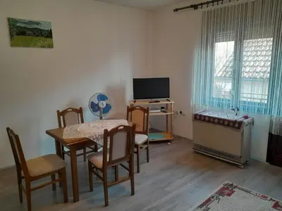 a living room with a table and chairs and a television at Nebo in Soko Banja