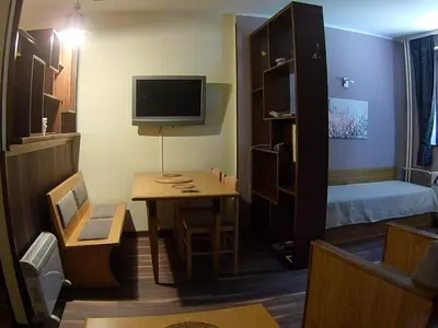 a small room with a small table and a bedroom at Vila Nikola 202 centar in Kopaonik