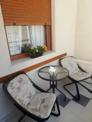 two chairs and a table in a room with a window at Nektar 88 Lux in Vrnjačka Banja