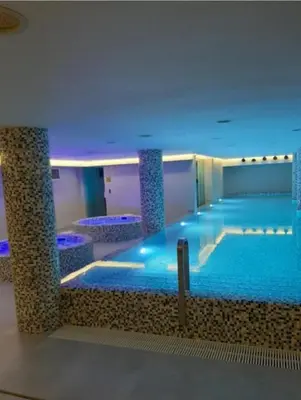 a large swimming pool with blue lighting in a building at Nektar 88 Lux in Vrnjačka Banja
