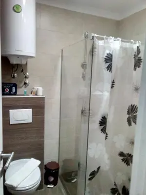 a bathroom with a shower with a toilet and a shower curtain at Kopaonik Milmari P50 in Kopaonik