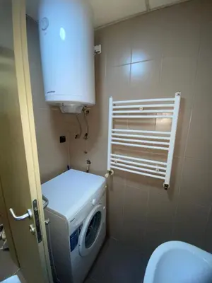 a bathroom with a washing machine and a toilet at Apartman Filip2 in Kruševac