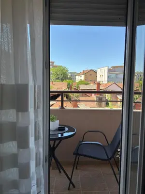 a balcony with a table and a chair and a window at Apartman Filip2 in Kruševac