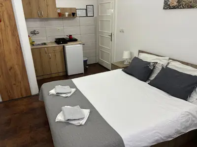 a bedroom with a large bed with two towels on it at Apartments Ozren in Soko Banja
