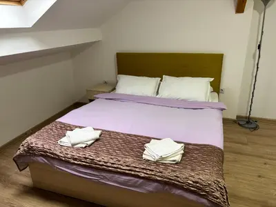 a bedroom with a bed with two towels on it at Apartments Ozren in Soko Banja