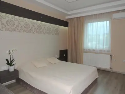 a bedroom with a white bed and a window at Guest House Dabi in Kruševac