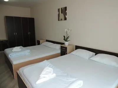 a room with two beds with white sheets at Guest House Dabi in Kruševac