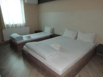 two twin beds in a room with a window at Guest House Dabi in Kruševac