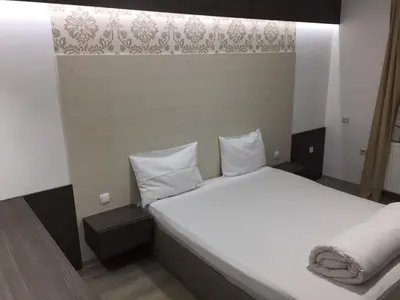 a bedroom with a large bed with white sheets and pillows at Guest House Dabi in Kruševac