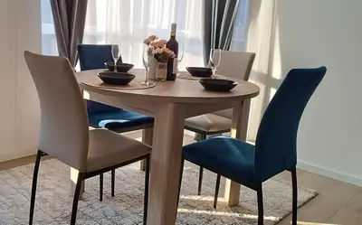 a wooden table with chairs and a bottle of wine at Golden Roses Apartment in Niš