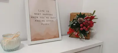 a mirror sitting on a shelf with a vase of flowers at Golden Roses Apartment in Niš