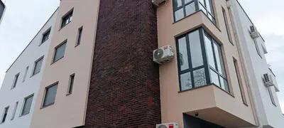 a tall brick building with a large window at Golden Roses Apartment in Niš