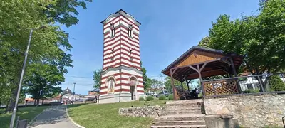 a clock tower in the middle of a park at Golden Roses Apartment in Niš