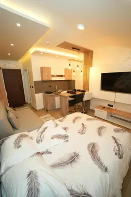 a large bed in a living room with feathers on it at Residence Hill - Planinski Kutak in Kopaonik