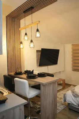 a dining room with a table and a television at Residence Hill - Planinski Kutak in Kopaonik