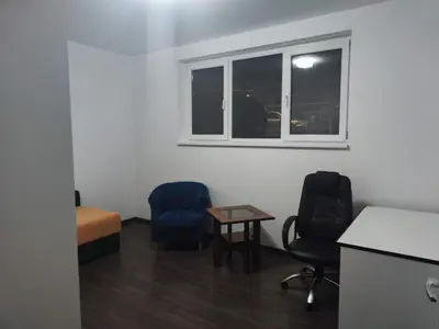 a room with two chairs and a table and a window at Sudent Rooms in Niš