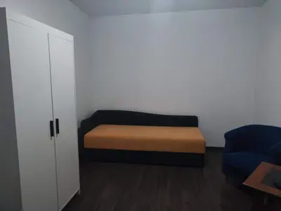 a small room with a bed and a cabinet at Sudent Rooms in Niš
