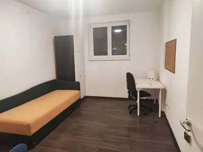 a small room with a bed and a desk at Sudent Rooms in Niš