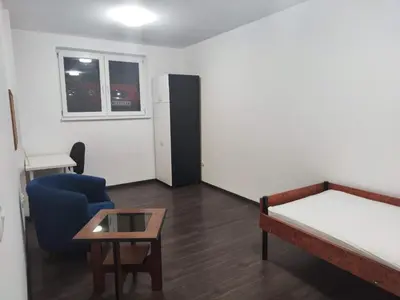 a room with a bed and a chair and a table at Sudent Rooms in Niš